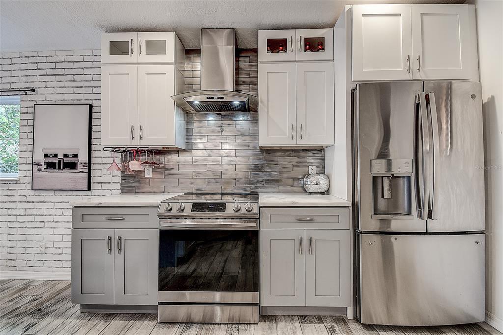 9641 Fulton Avenue Hudson, FL 34667 - Photo 16 of 60 a kitchen with appliances a refrigerator and cabinets