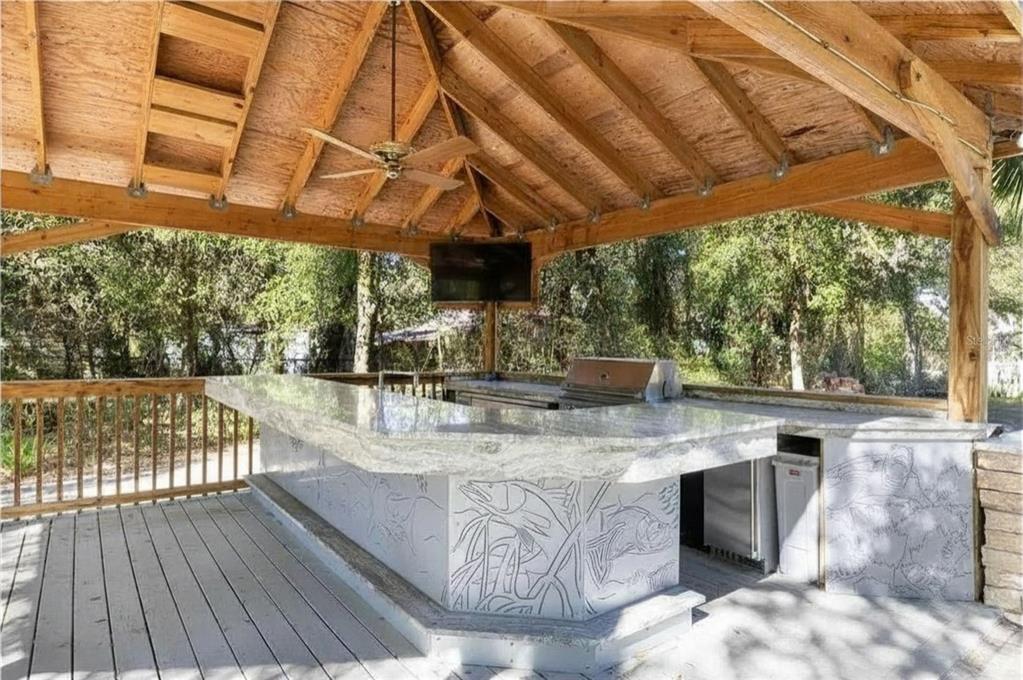 9641 Fulton Avenue Hudson, FL 34667 - Photo 44 of 60 a view of a backyard with table and chairs under an umbrella with a small yard