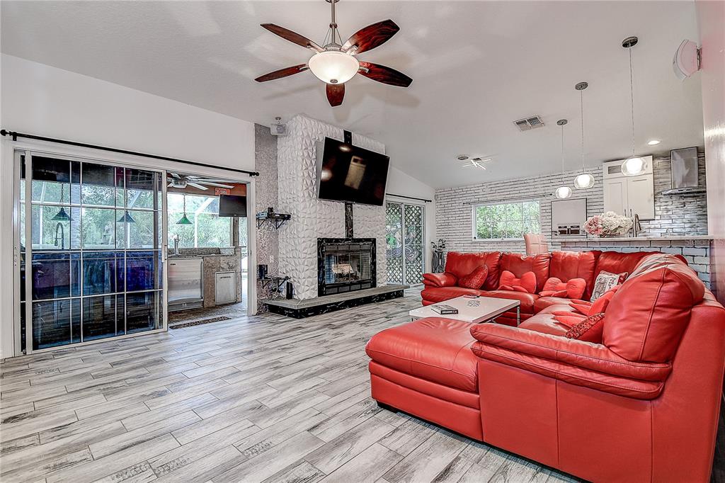 9641 Fulton Avenue Hudson, FL 34667 - Photo 7 of 60 a living room with furniture a flat screen tv and a fireplace