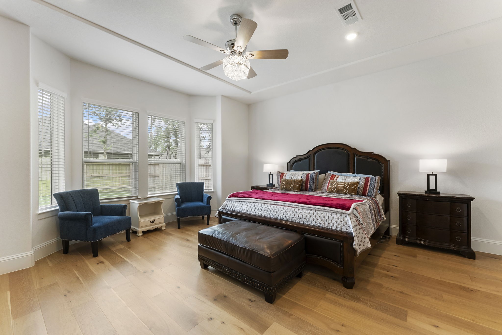 12932 Whitewater Way Conroe, TX 77302 - Photo 14 of 48 The spacious primary bedroom offers a cozy bay window sitting area and stylish fandelier.