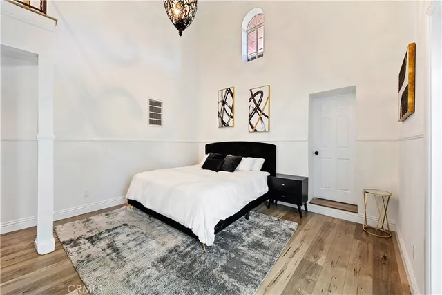 a bedroom with a bed and wooden floor