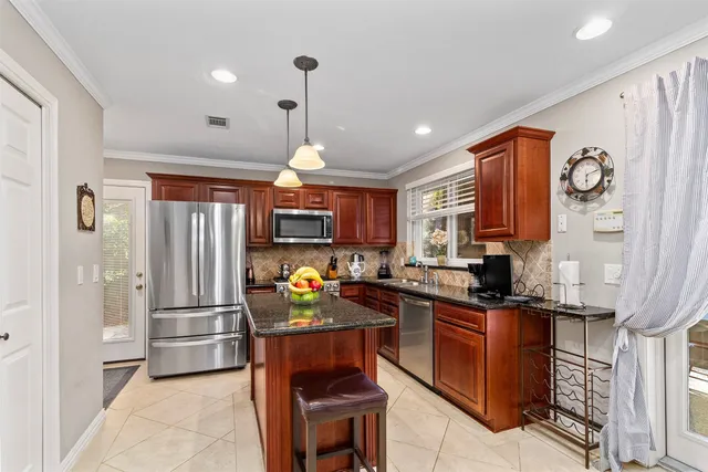 a kitchen with stainless steel appliances granite countertop a refrigerator and a stove top oven