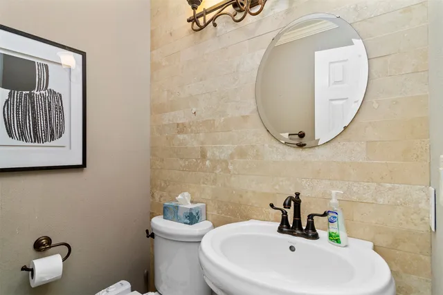 a bathroom with a sink a toilet and a mirror