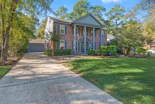 a front view of a house with a yard and trees