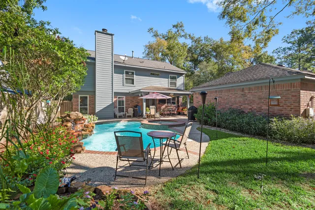 a view of a house with backyard sitting area and garden