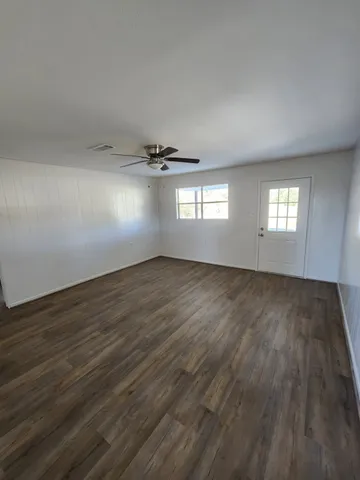 a view of empty room with wooden floor