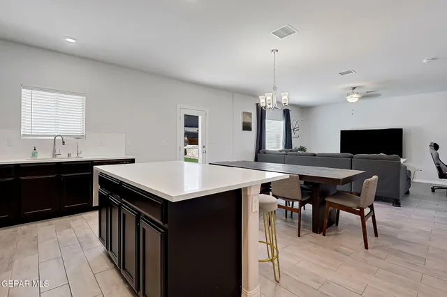 a kitchen with a stove a sink dishwasher with a dining table and chairs