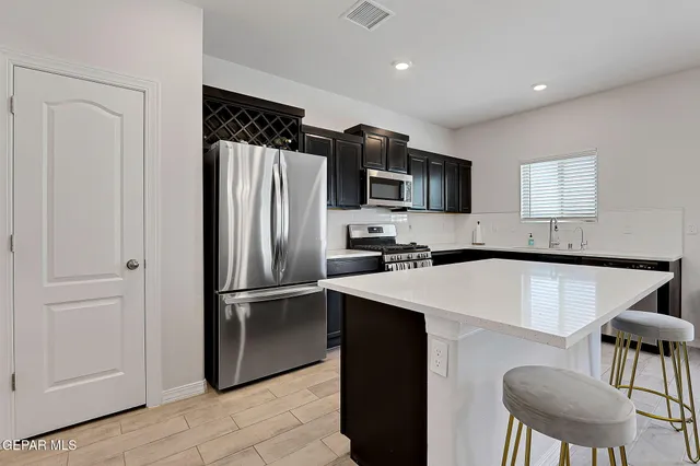 a kitchen with stainless steel appliances a refrigerator stove microwave and white cabinets