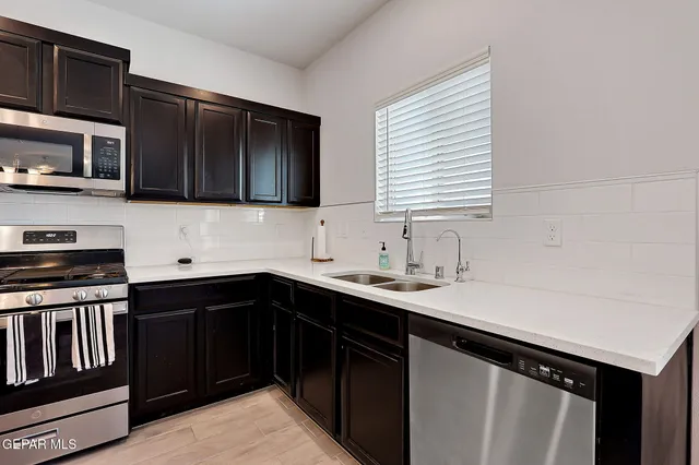 a kitchen with stainless steel appliances a sink stove and cabinets