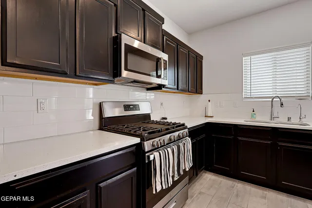 a kitchen with stainless steel appliances a sink dishwasher stove microwave and cabinets