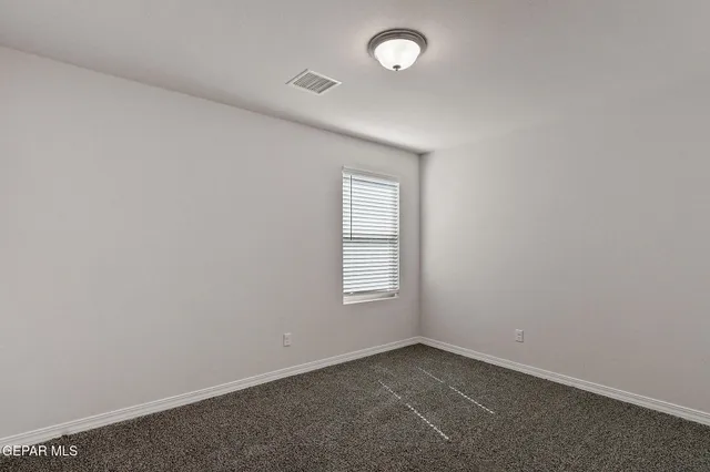 a bedroom with bed and paintings on the wall
