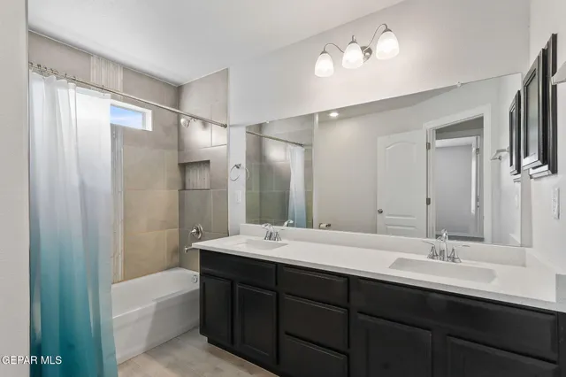 a bathroom with a double vanity sink and mirror