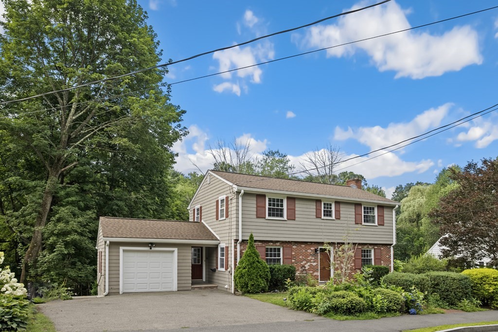 58 Oak Street Reading, MA 01867 - Photo 1 of 40 a front view of a house with yard and trees