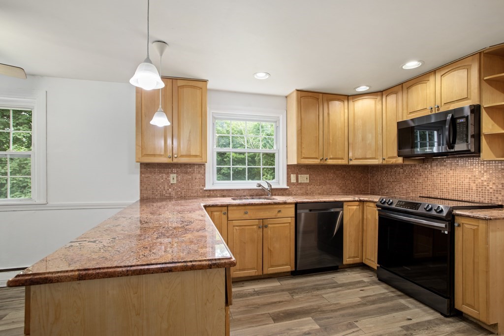 58 Oak Street Reading, MA 01867 - Photo 8 of 40 a kitchen with stainless steel appliances granite countertop a sink and a stove