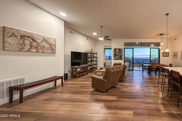 a living room with furniture kitchen view and a large window