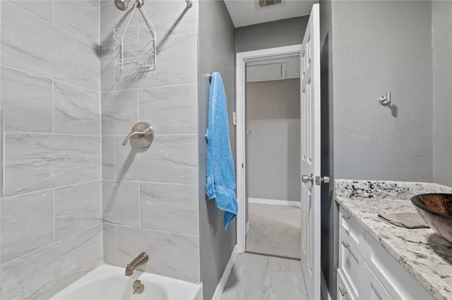 a bathroom with a granite countertop sink a toilet and shower