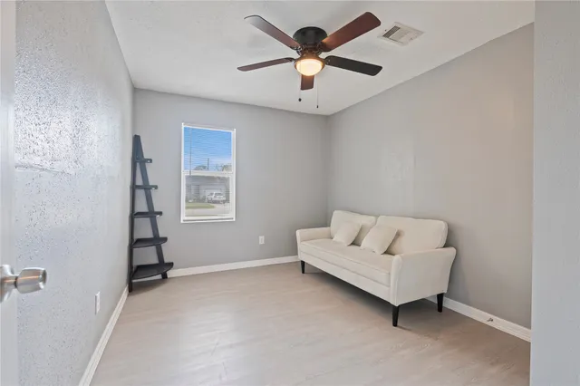 a living room with furniture and a ceiling fan