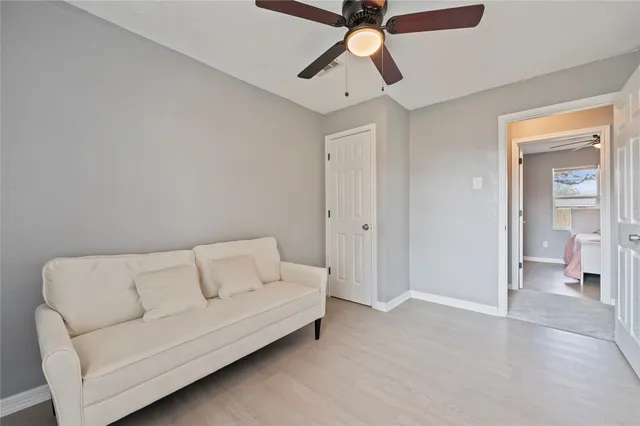 a living room with furniture and a ceiling fan