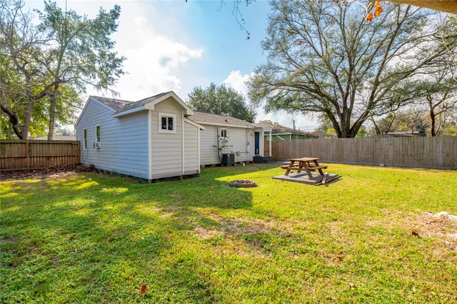 a view of a backyard with a large tree and wooden fence