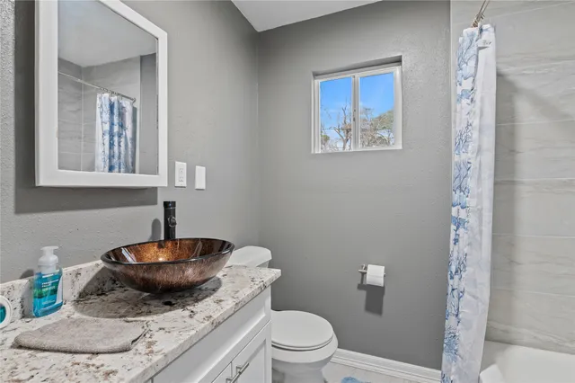 a bathroom with a toilet a sink and a mirror