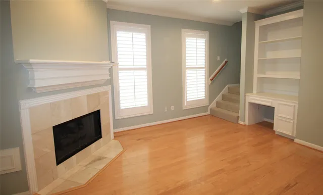 a view of an empty room with fireplace and a window