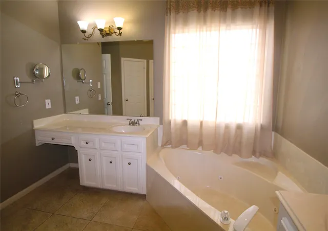 a bathroom with a tub sink and mirror