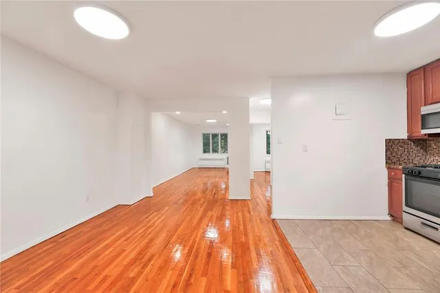 a view of empty room with wooden floor and fireplace