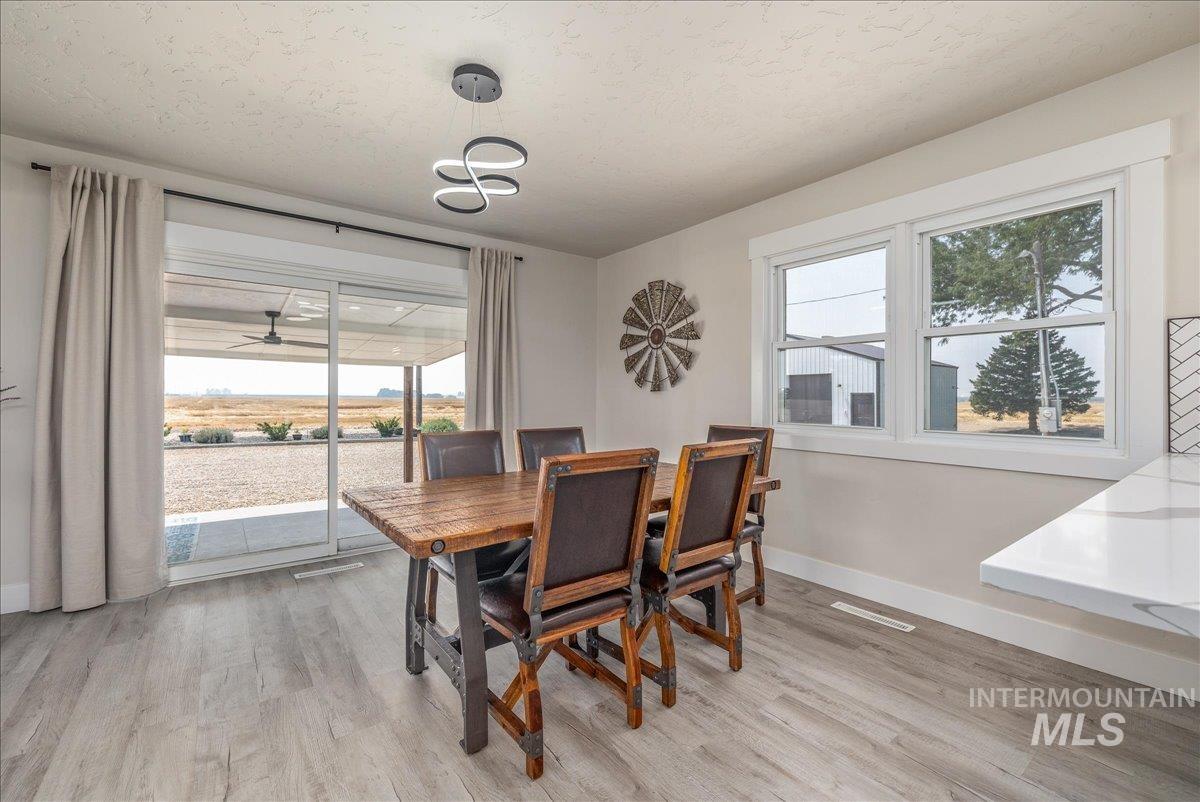 23011 Allendale Road Parma, ID 83660 - Photo 14 of 50 Recessed lighting, wood-finish flooring, sliding glass door, white window trim, and a white countertop