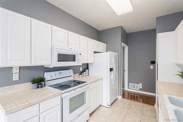 a kitchen with stainless steel appliances white cabinets and a refrigerator