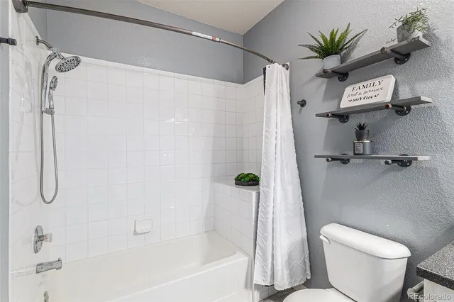 a bathroom with a shower a toilet and a shower