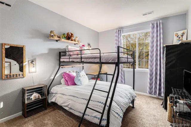 a bedroom with bed and a flat tv screen on dresser
