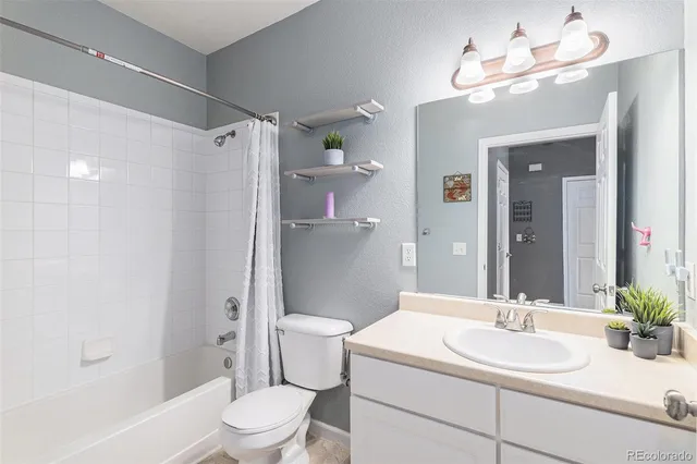 a bathroom with a sink a toilet and shower a mirror