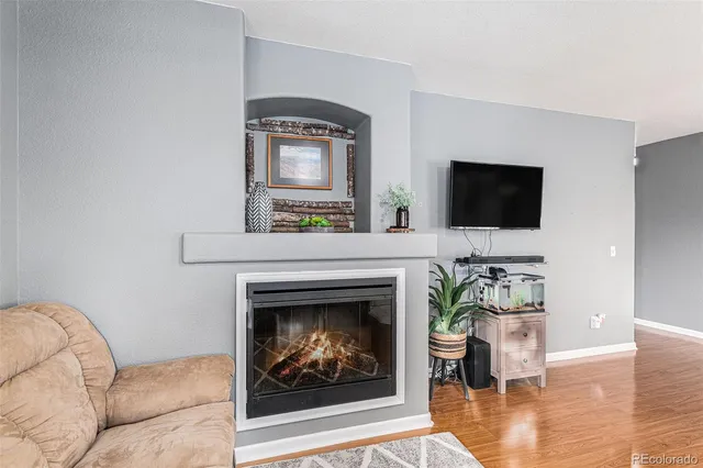 a living room with furniture a flat screen tv and a fireplace