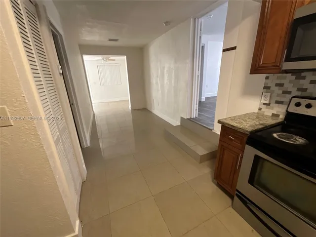 a kitchen with granite countertop a stove and a refrigerator