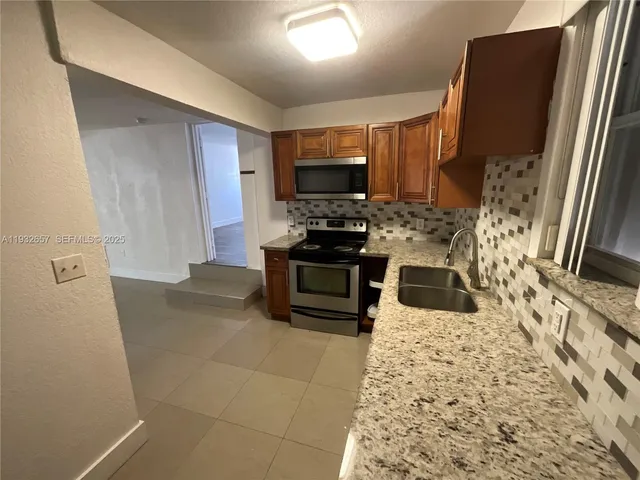 a kitchen with stainless steel appliances a stove microwave and a refrigerator