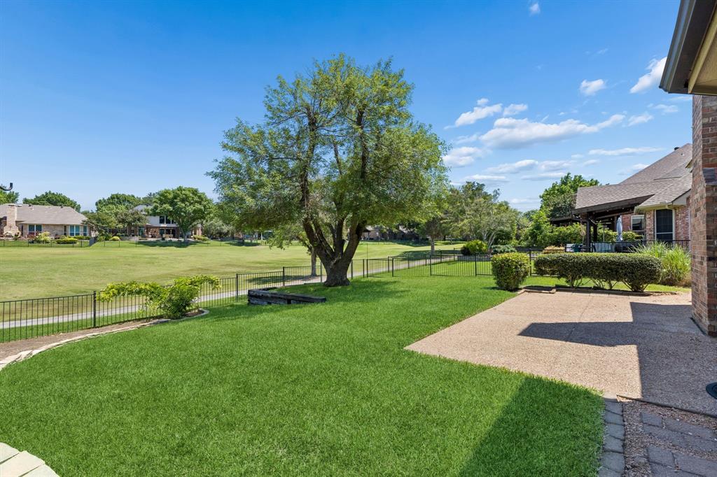 2925 Sunset Ridge McKinney, TX 75072 - Photo 32 of 33 Expansive backyard retreat overlooking the pristine fairways of Eldorado Golf Course, featuring lush landscaping, mature shade trees, and a spacious patio ideal for outdoor entertaining and relaxation.