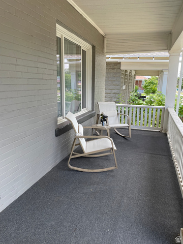 857 27th Street Ogden, UT 84403 - Photo 2 of 20 Covered front porch featuring a gray brick exterior, white window trim, white porch railing, and a gray floor