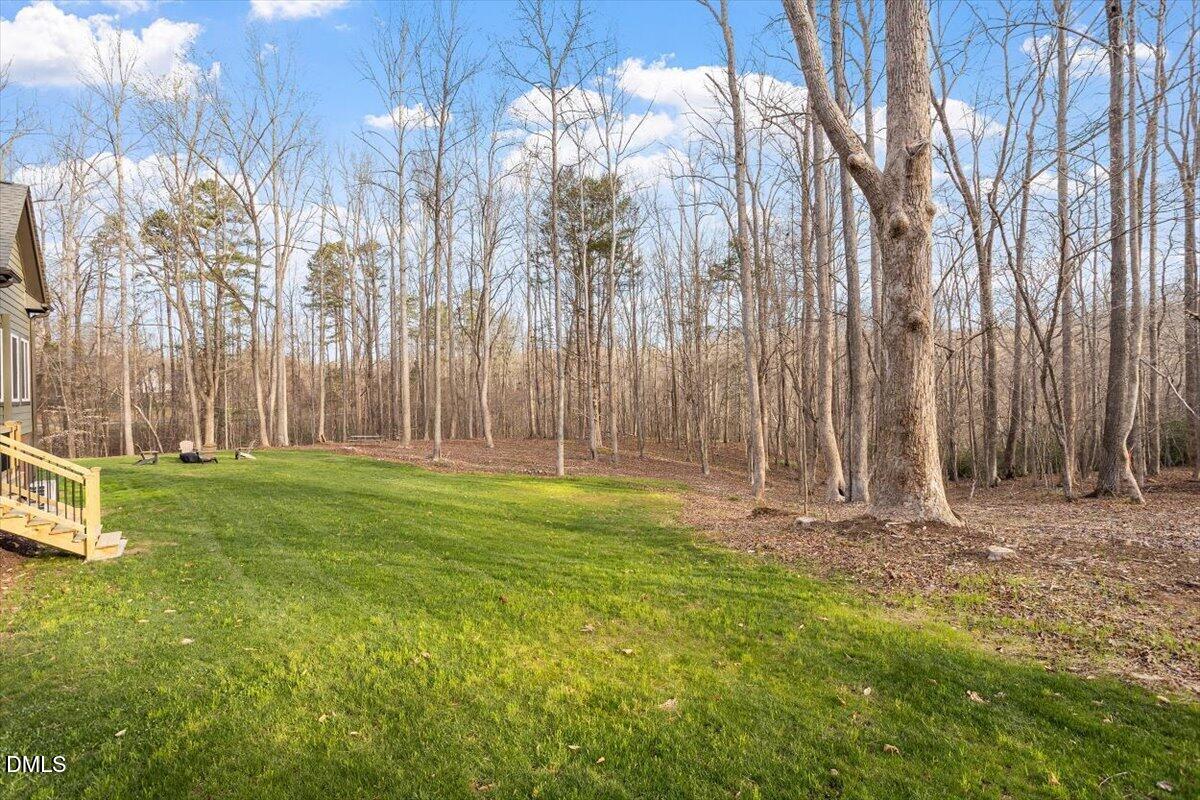 31 River View Court Timberlake, NC 27583 - Photo 40 of 44 a backyard of apartments with large trees and wooden fence