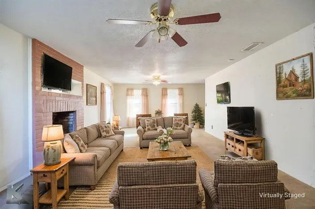 a living room with furniture a fireplace and a flat screen tv