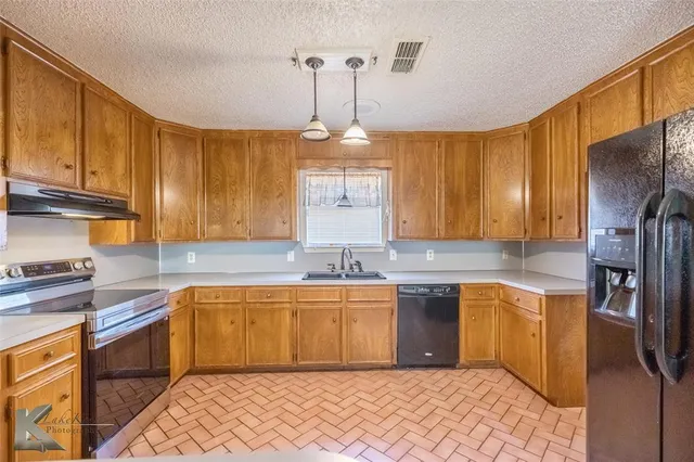 a kitchen with a sink refrigerator and cabinets