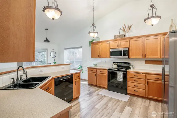 a kitchen with stainless steel appliances granite countertop a sink stove and refrigerator