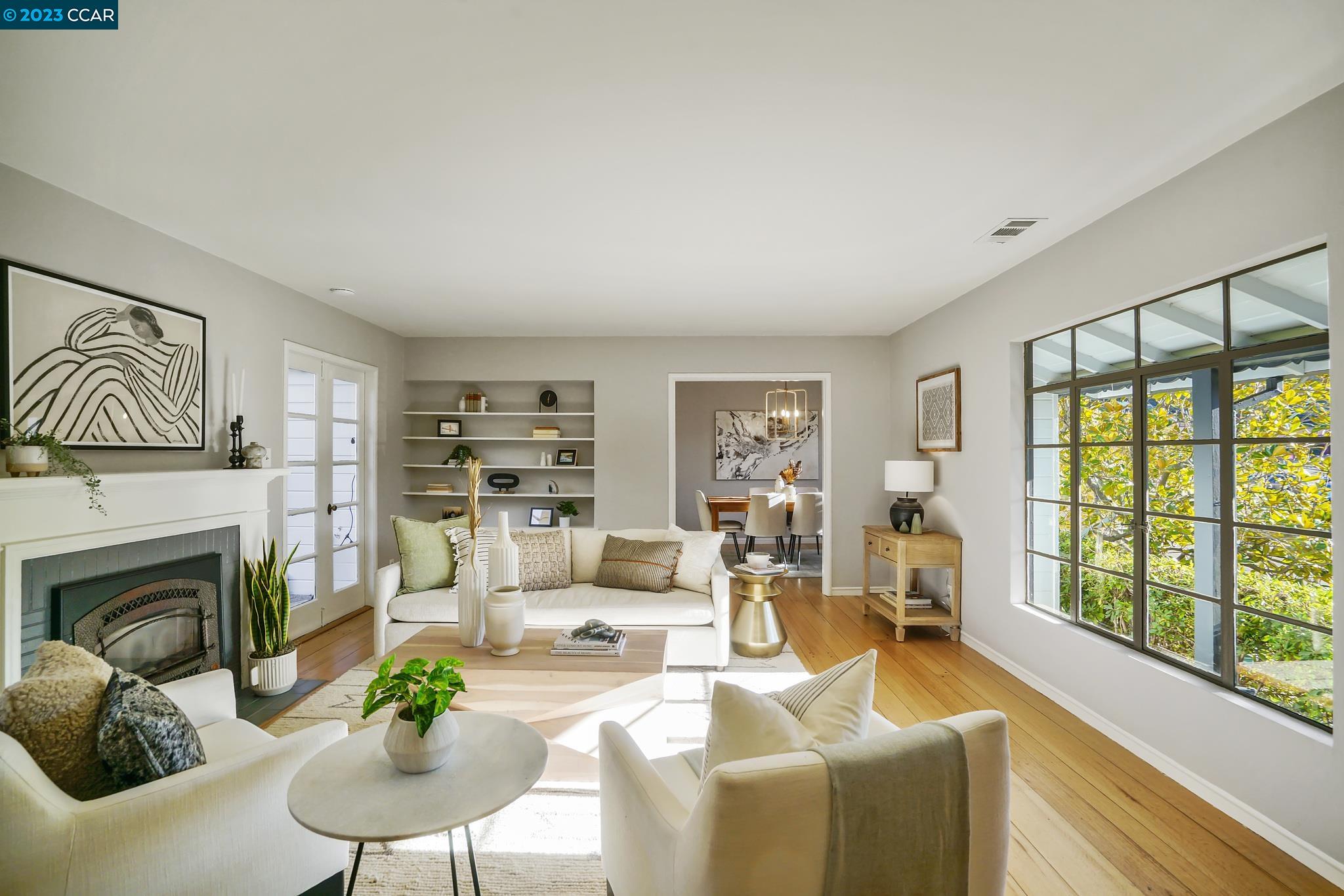 a living room with furniture fireplace and a large window