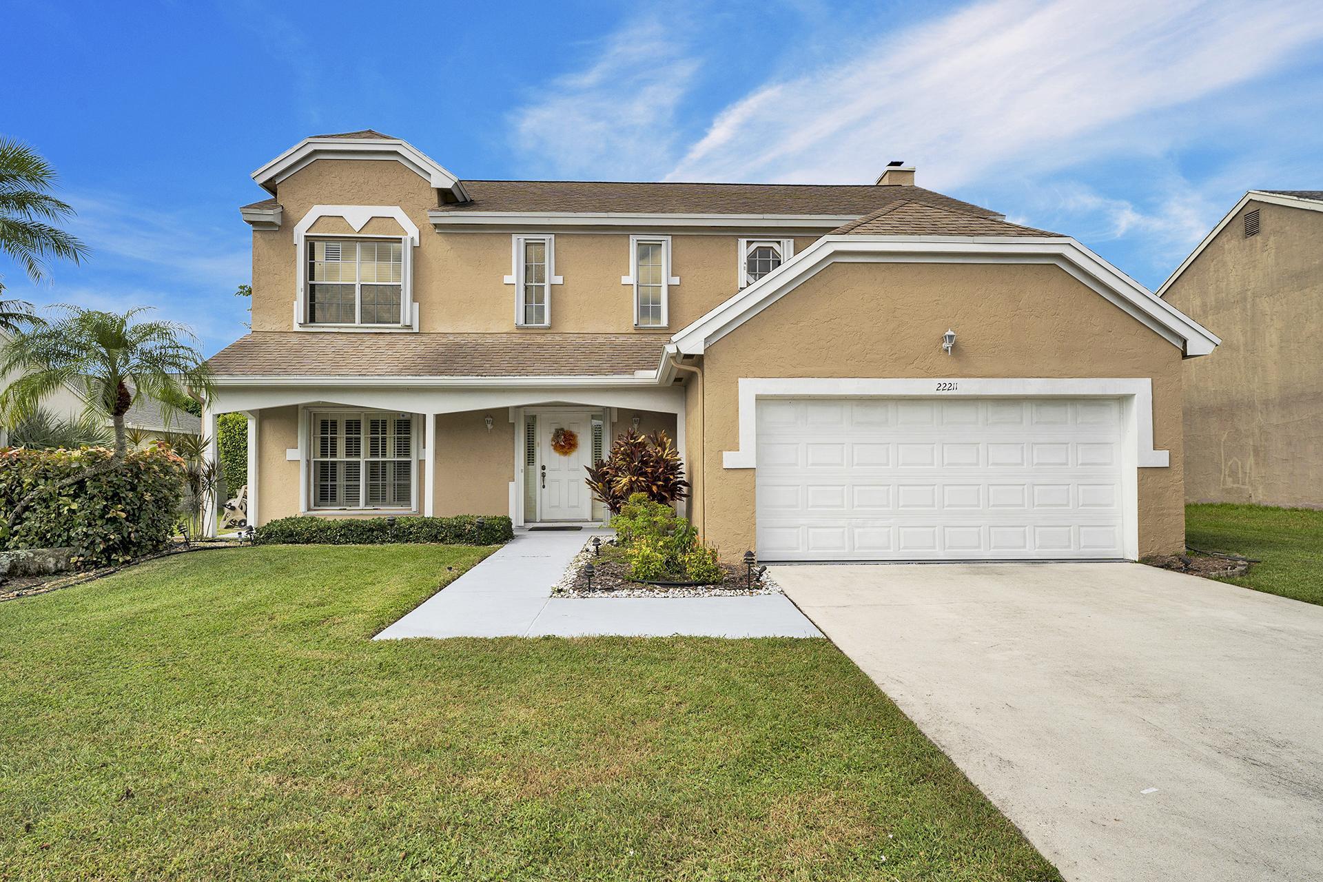 22211 Clocktower Way Boca Raton, FL 33428 - Photo 1 of 38 a front view of a house with a yard and garage