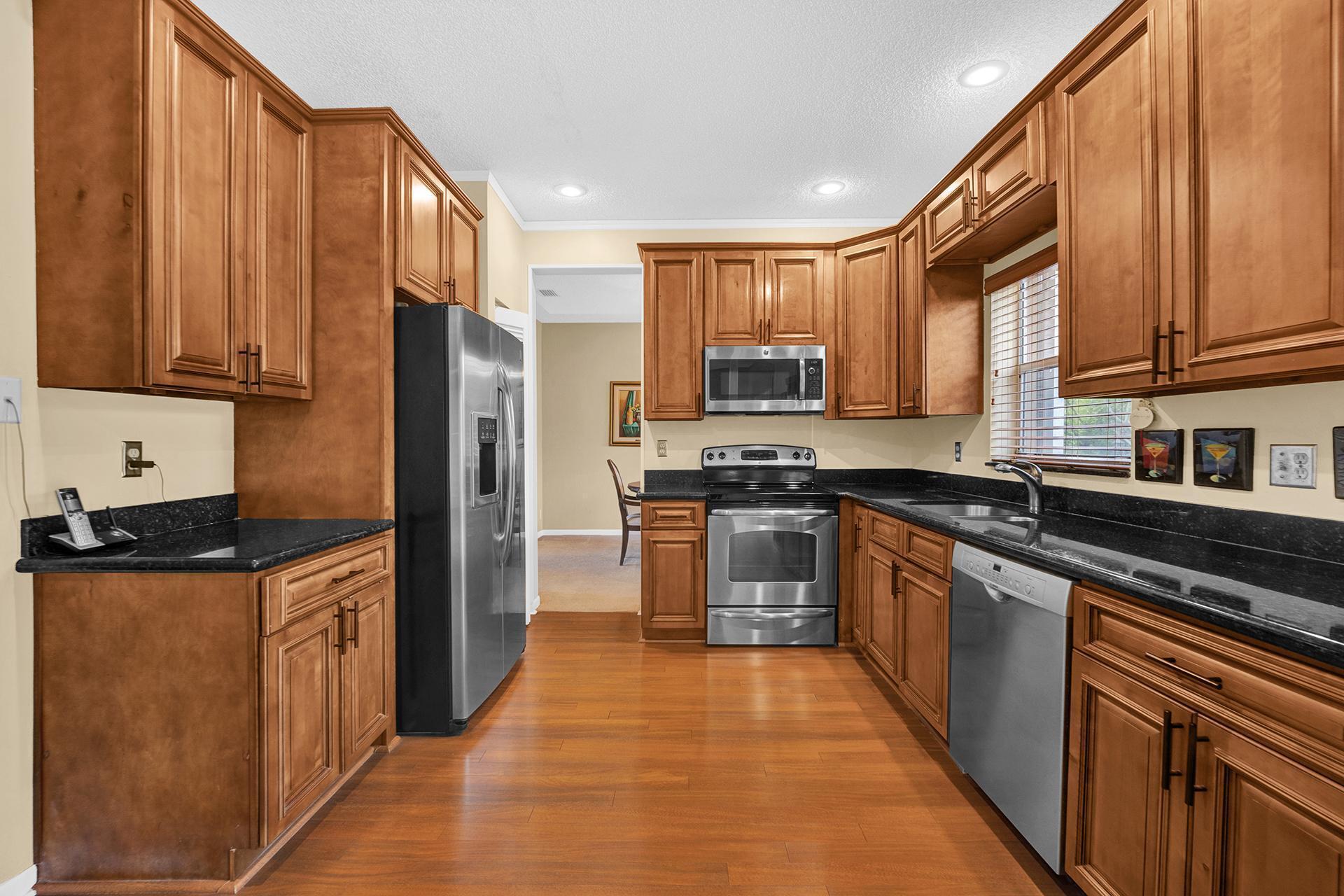 22211 Clocktower Way Boca Raton, FL 33428 - Photo 14 of 38 a kitchen with stainless steel appliances granite countertop a refrigerator a stove top oven and a sink