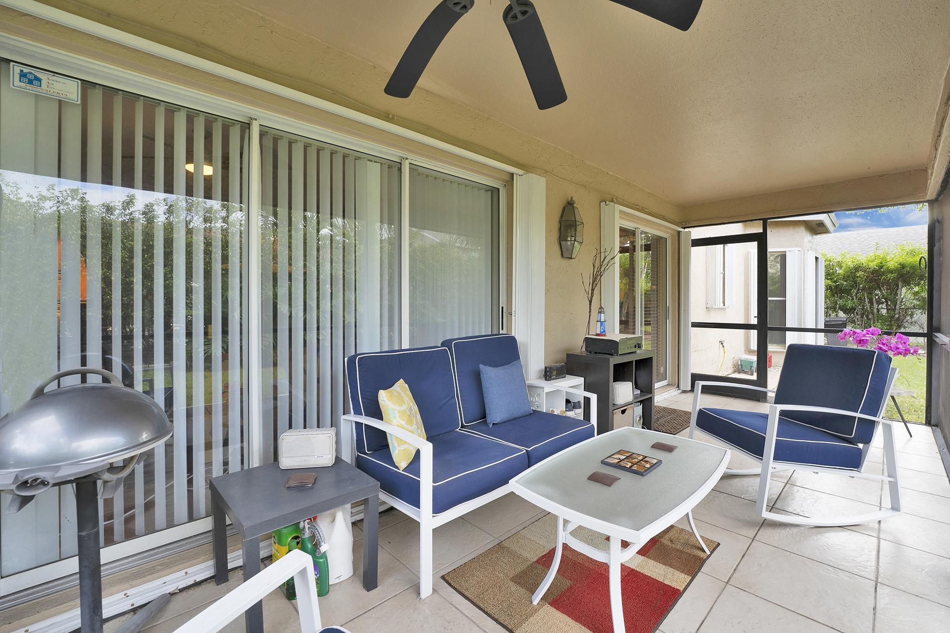 22211 Clocktower Way Boca Raton, FL 33428 - Photo 30 of 38 a living room with furniture a rug and a chandelier