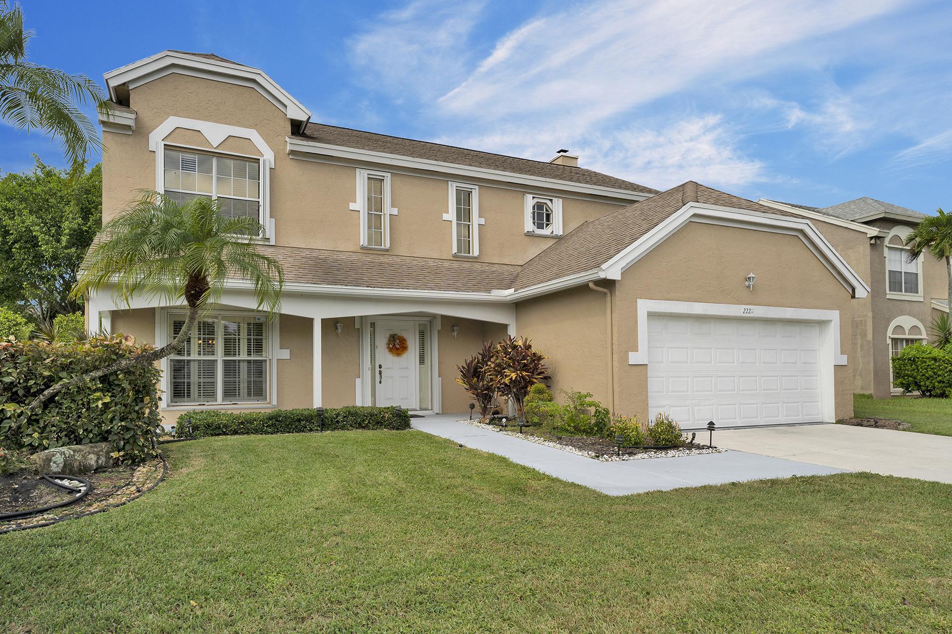 22211 Clocktower Way Boca Raton, FL 33428 - Photo 4 of 38 a front view of a house with a yard and garage