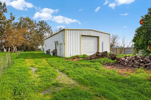 a view of a backyard with potted plants and wooden fence