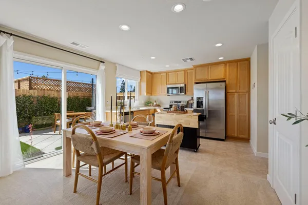 a kitchen with a table chairs refrigerator and cabinets