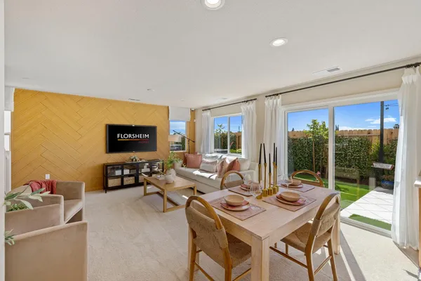 a living room with furniture a flat screen tv and a floor to ceiling window