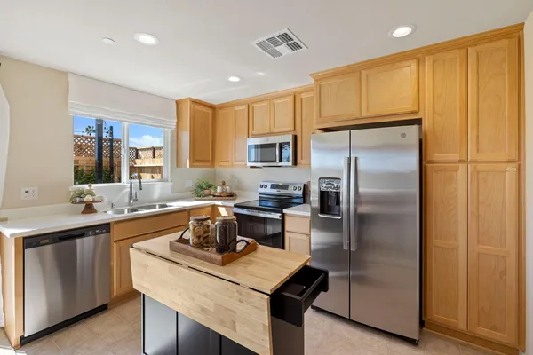 a kitchen with kitchen island a sink stove and refrigerator